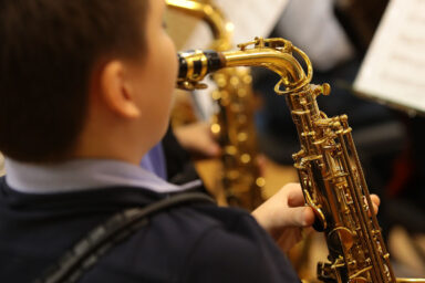 Un enfant joue au saxophone.